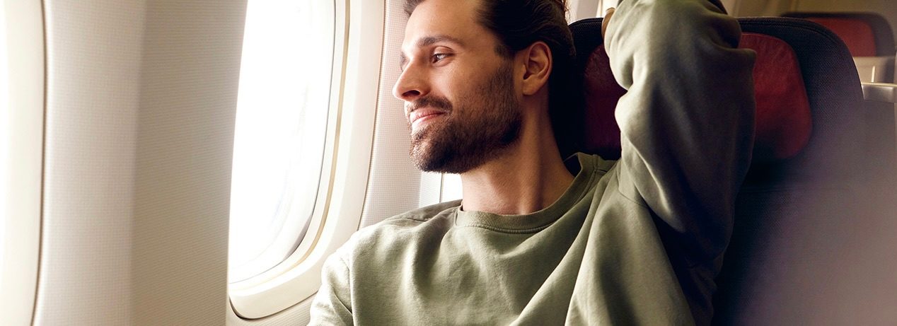 A man sitting in the aircraft looking out of the window.