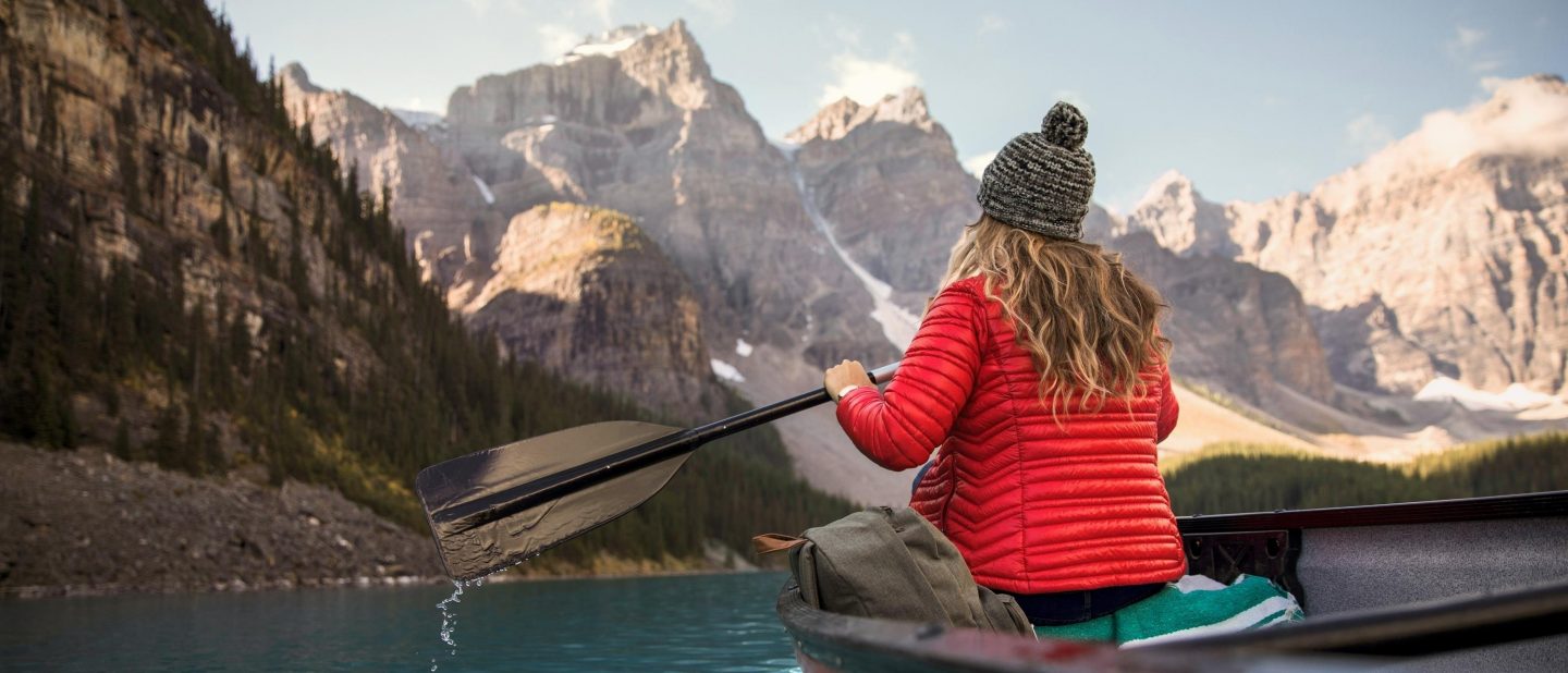 A young woman taking in the scenic view of Lake Moraine from a canoe