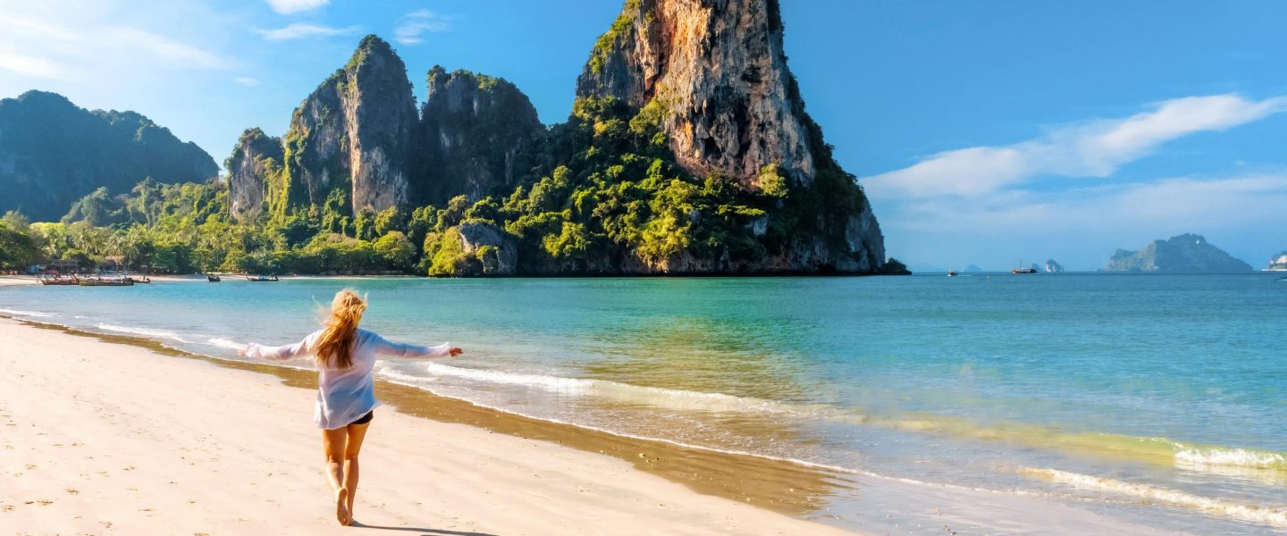 Woman running on amazing Railay beach in Krabi Thailand. Tropical resort.