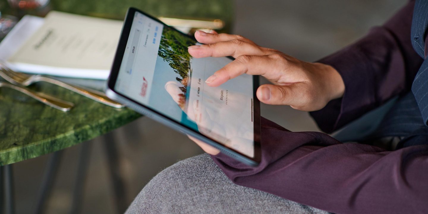 Person betrachtet Austrian Website auf Tablet