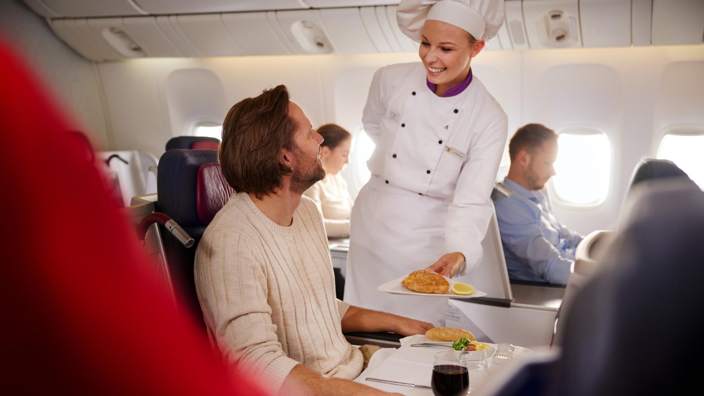 Female chef serving food to a passenger.