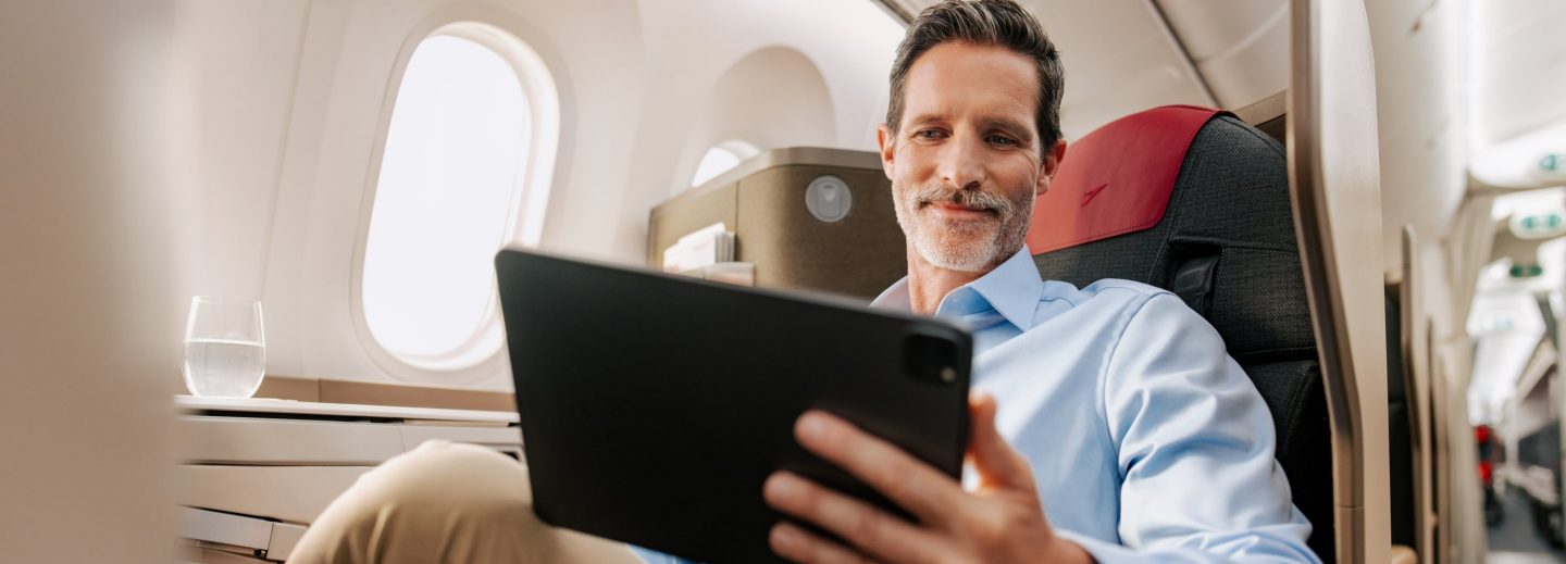 Passagier in der Business Class nutzt ein Tablet.