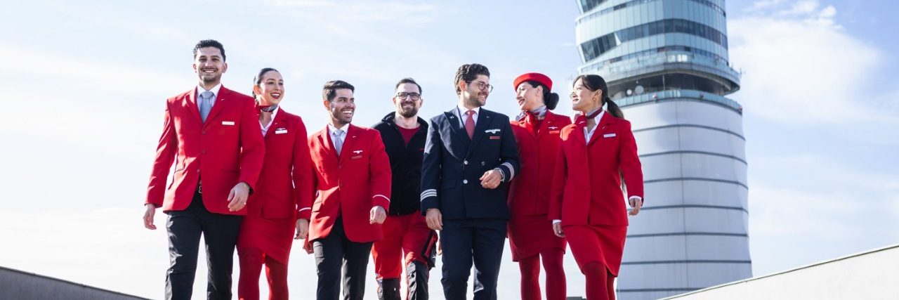 Austrian Airlines flight crew and pilots walking on the airport tarmac.