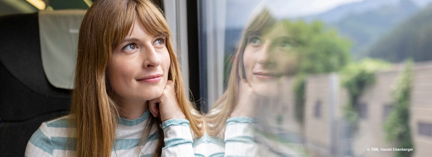 Woman sitting at a window looking at the countryside.