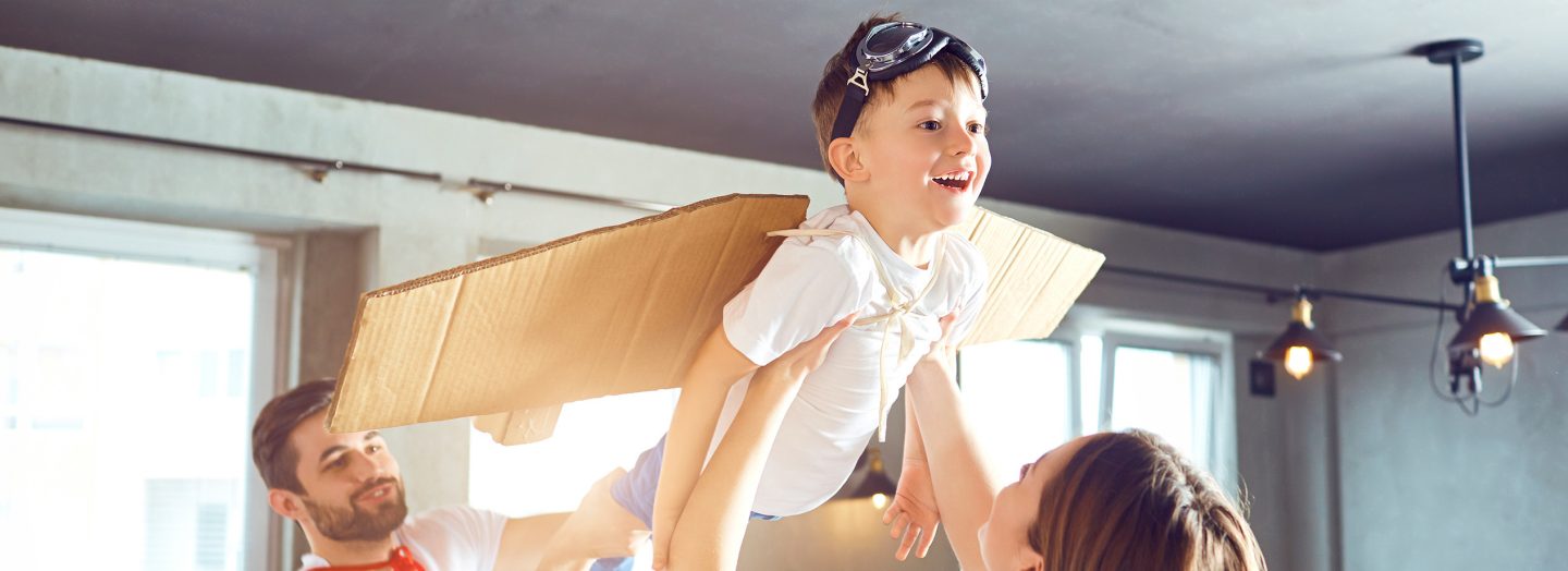Parents playfully lift their child up in the air