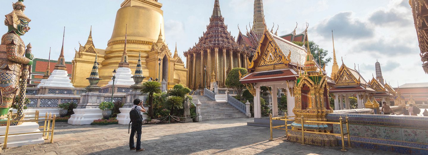 A tourist photographing a temple in Bangkok