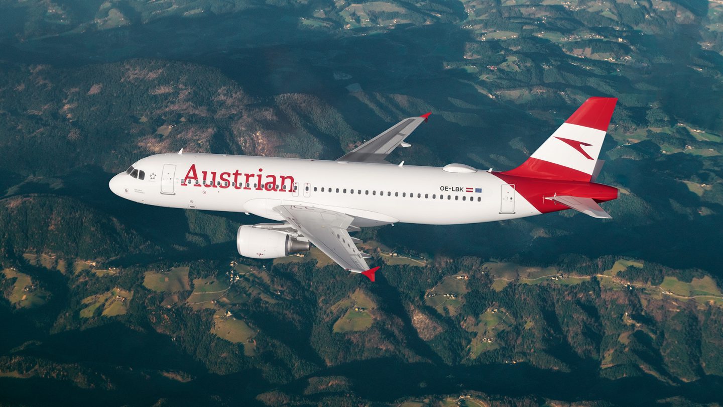 Austrian plane flies over green mountains