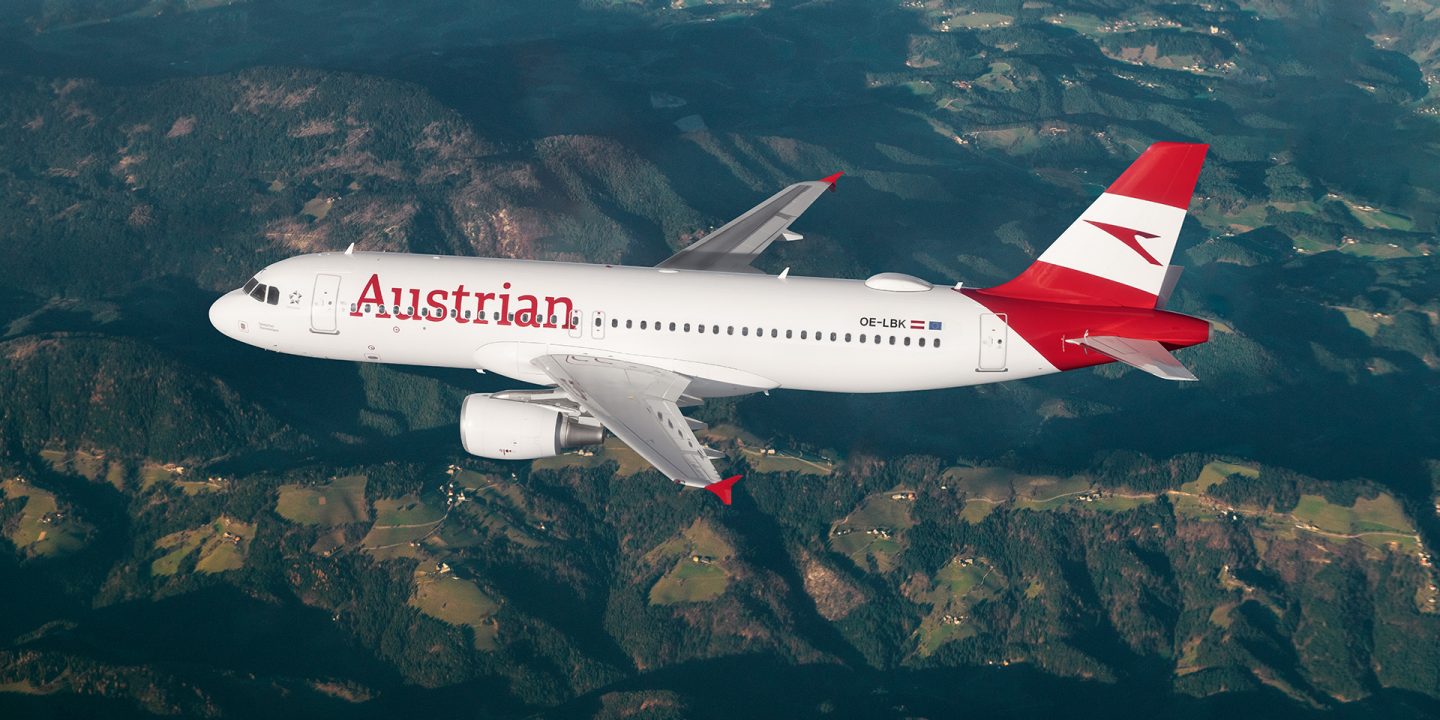 Austrian plane flies over green mountains