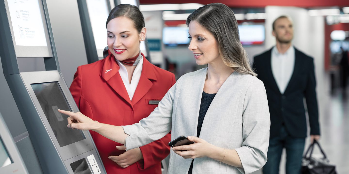 Austrian staff helps women at the airport terminal