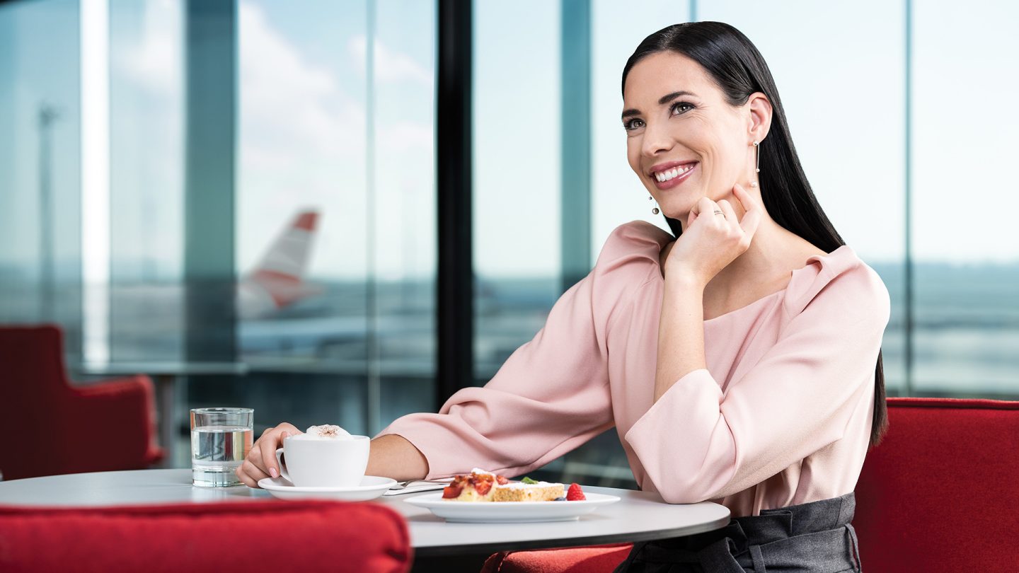 Women eats cake in the business class lounge