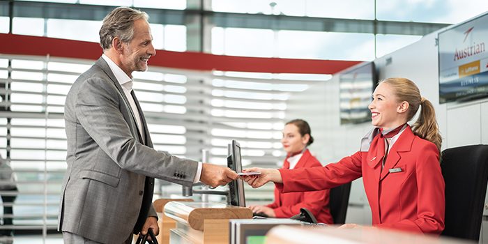 Businessman receives his boarding card at the check-in counter