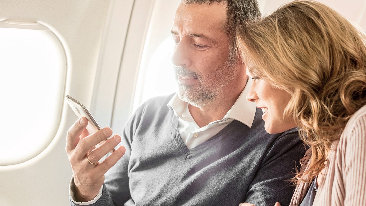 A couple of passengers looks at a smartphone