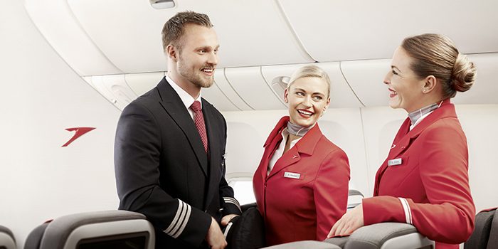 An Austrian pilot in conversation with two flight attendants