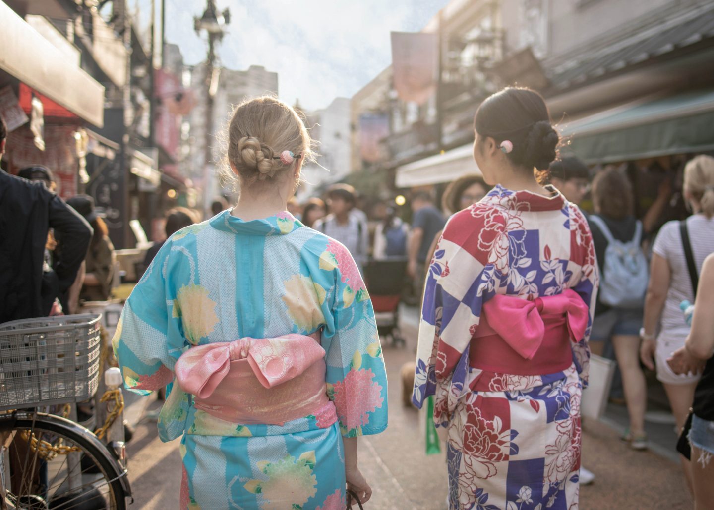 Multi-ethnic group of female friends in yukata walking in traditional Japanese town